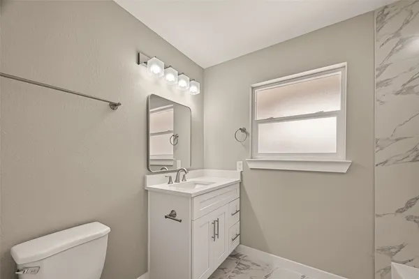 a bathroom with a sink mirror and a bathtub