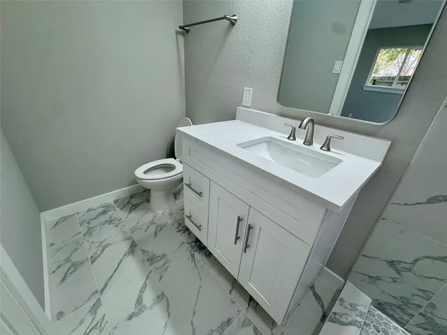 a bathroom with a sink toilet and mirror