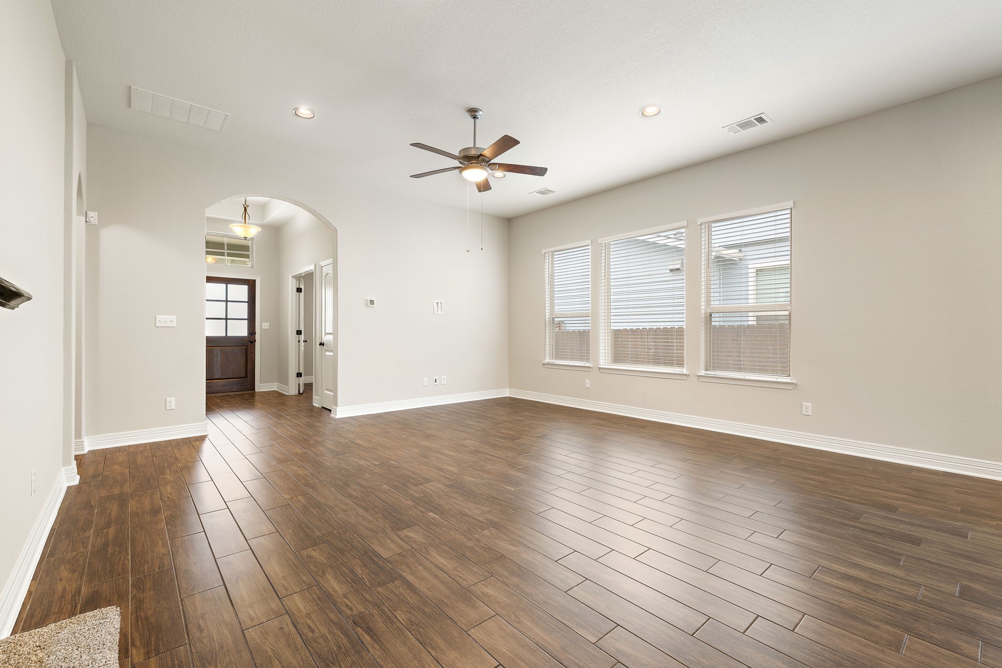 2137 Ringstaff Road Leander, TX 78641 - Photo 4 of 40 Spacious open concept living room with wood-looking tile throughout main floor living/dining/kitchen areas.