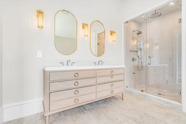 a bathroom with a double vanity sink mirror and shower