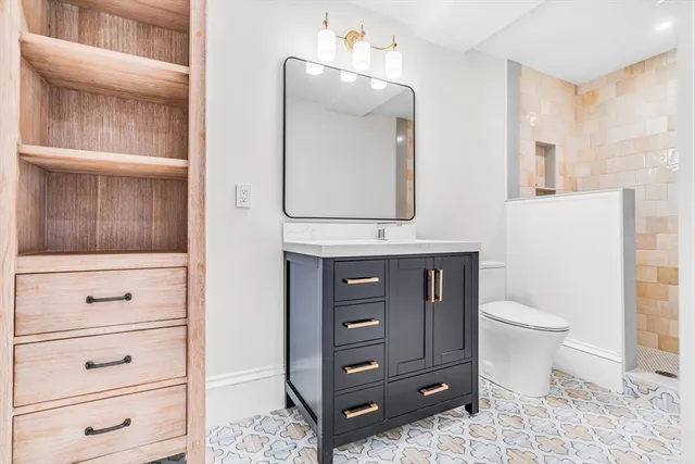 a bathroom with a toilet a sink and a mirror