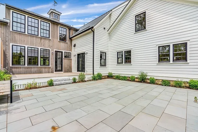 a front view of a house with a yard and potted plants