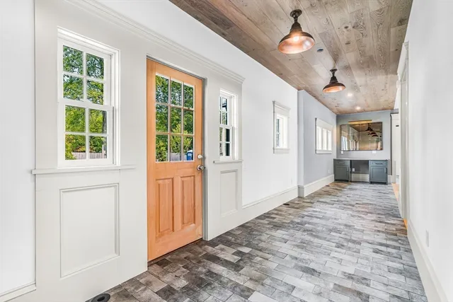 a view of an entryway with wooden floor and a kitchen