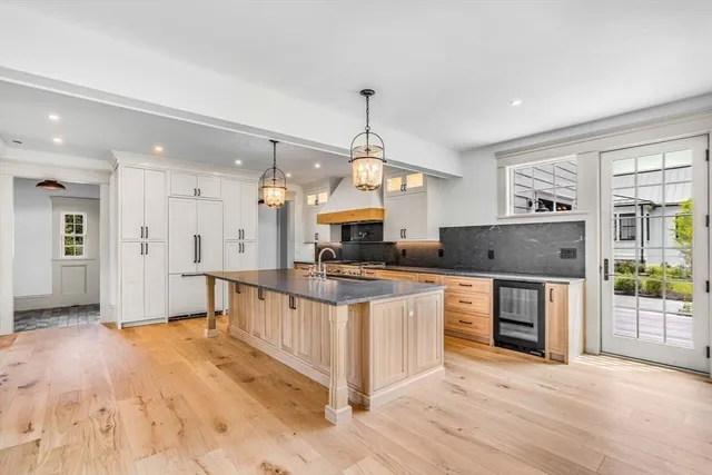 a large kitchen with stainless steel appliances granite countertop a stove a sink a refrigerator a center island and a stove