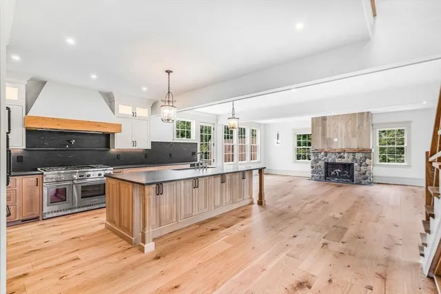 a kitchen with stainless steel appliances granite countertop a stove and a wooden floors