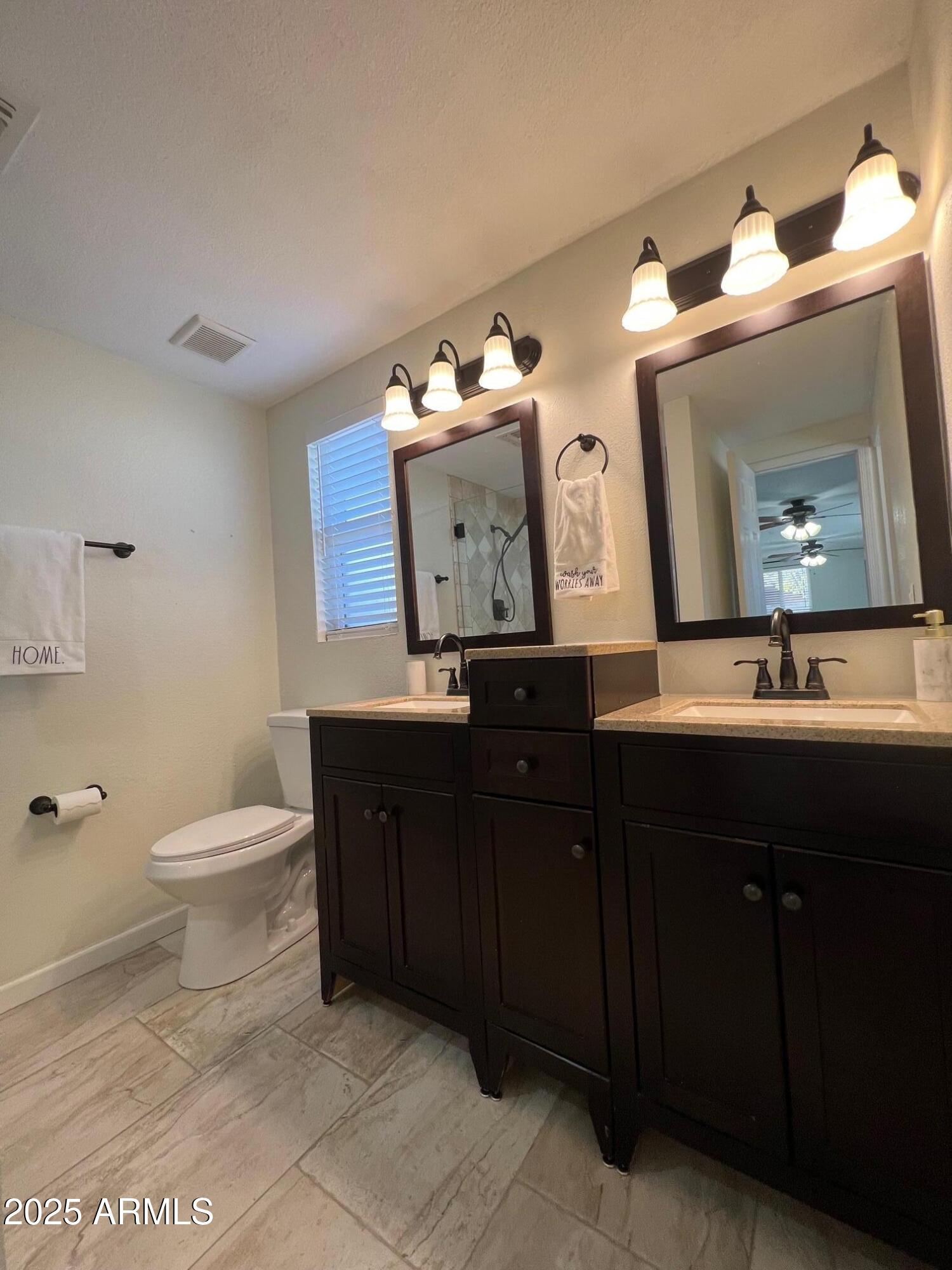 6711 North 14th Place Phoenix, AZ 85014 - Photo 10 of 27 a bathroom with a toilet a sink and mirror