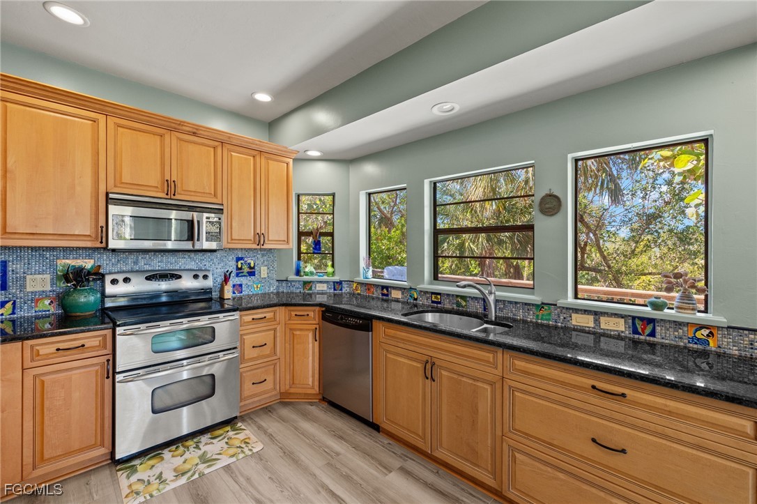 4631 Bowen Bayou Road Sanibel, FL 33957 - Photo 13 of 39 a kitchen with stainless steel appliances granite countertop a stove sink and cabinets