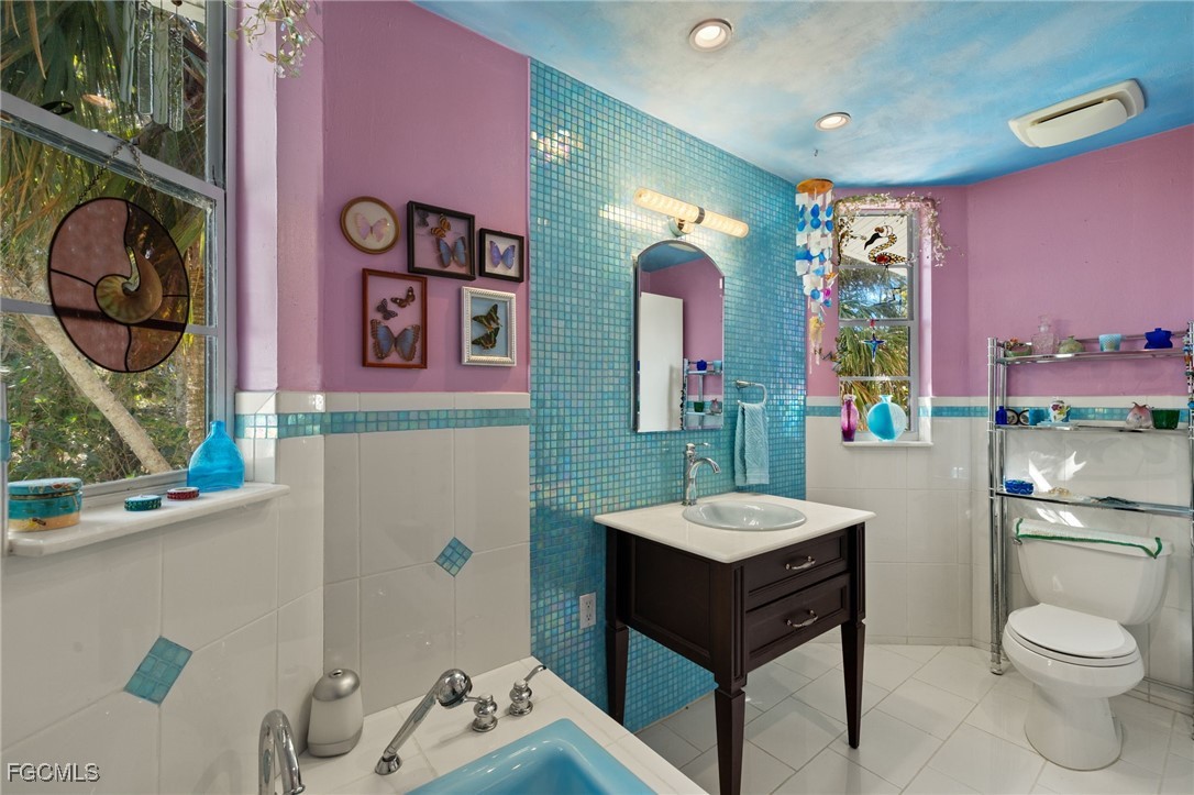 4631 Bowen Bayou Road Sanibel, FL 33957 - Photo 19 of 39 a bathroom with a granite countertop sink a toilet and a mirror