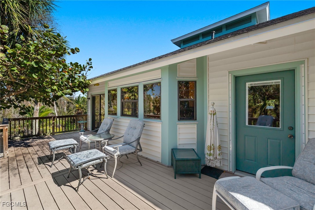4631 Bowen Bayou Road Sanibel, FL 33957 - Photo 26 of 39 a view of a patio with couches and table and chairs with wooden floor and fence