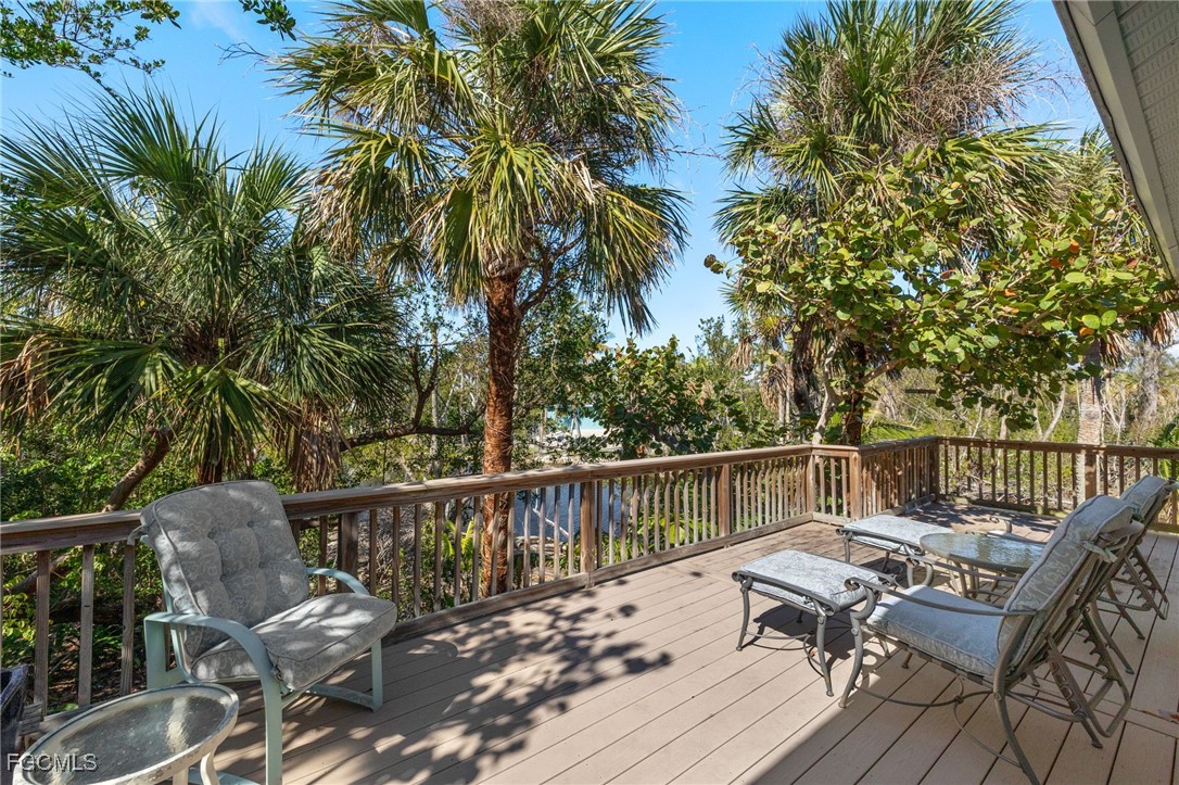 4631 Bowen Bayou Road Sanibel, FL 33957 - Photo 4 of 39 a balcony with wooden floor and outdoor seating
