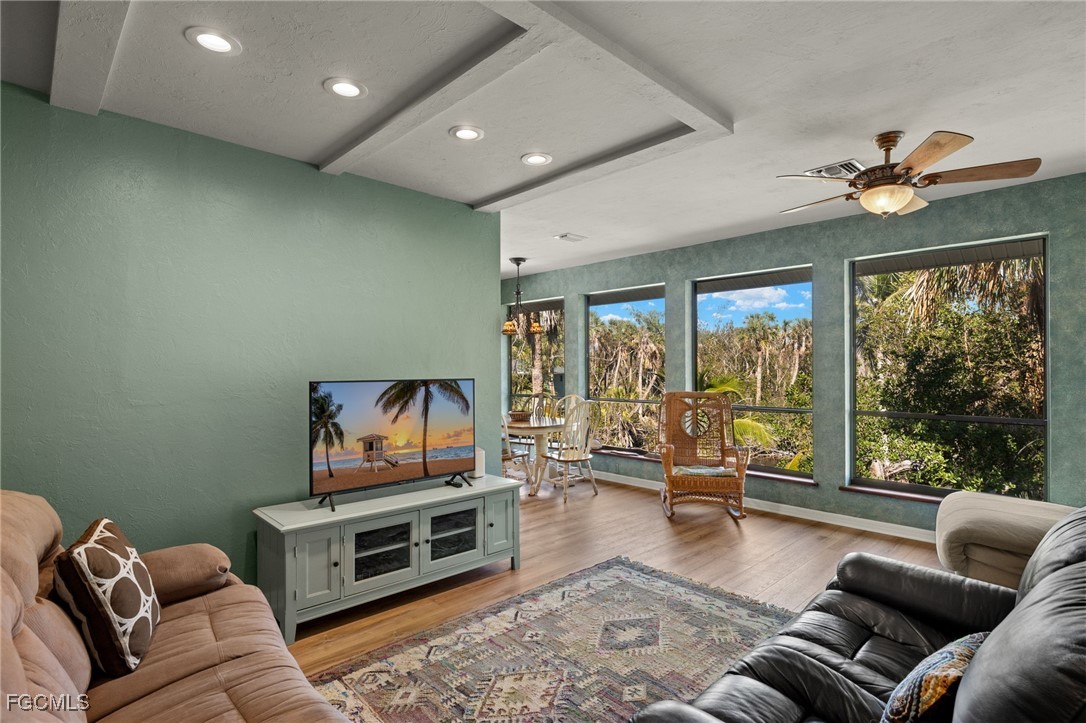 4631 Bowen Bayou Road Sanibel, FL 33957 - Photo 9 of 39 a living room with furniture floor to ceiling window and a flat screen tv