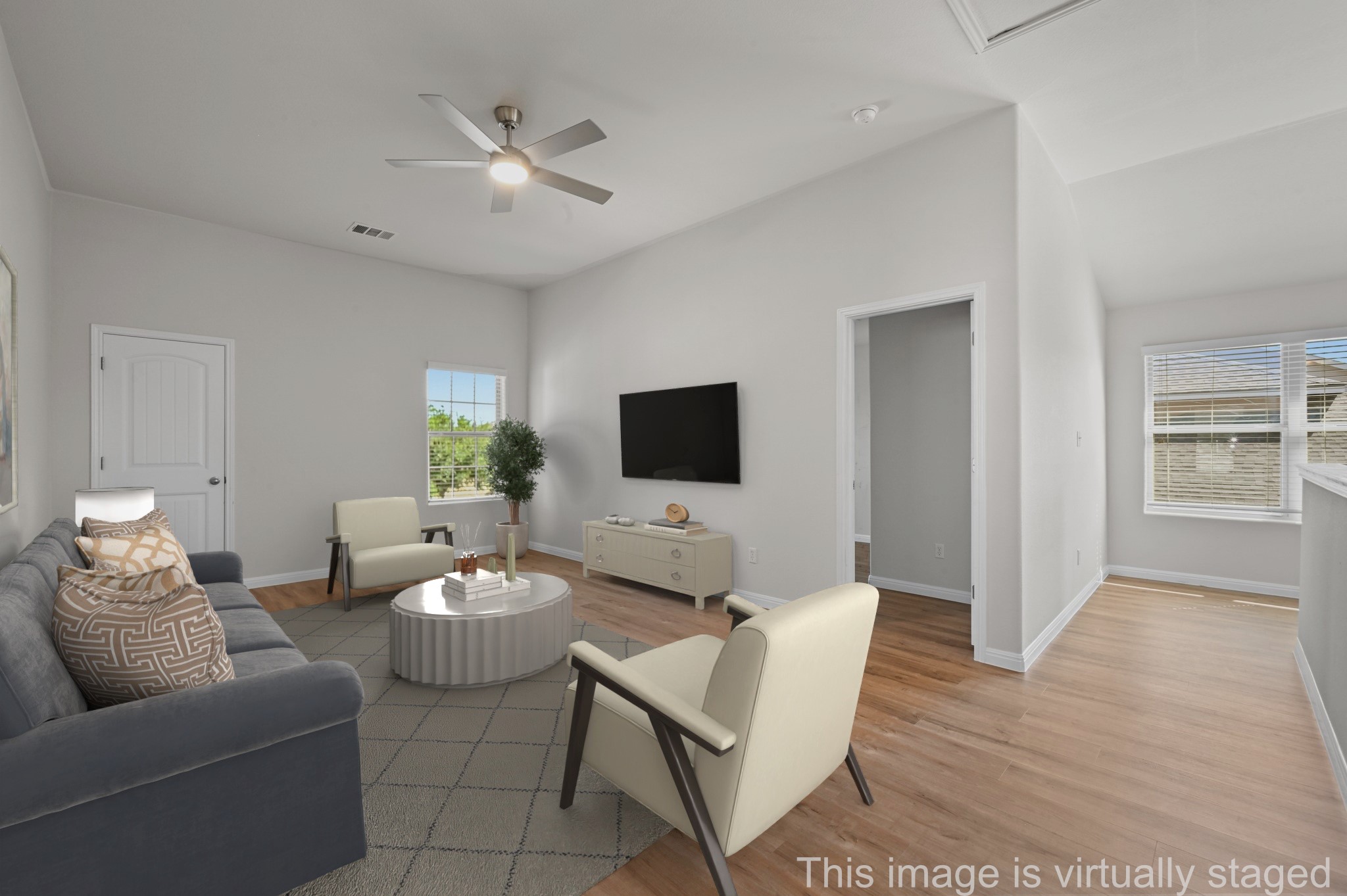 351 Wincliff Drive Buda, TX 78610 - Photo 10 of 40 A well-lit living area features warm wood flooring and a modern ceiling fan.