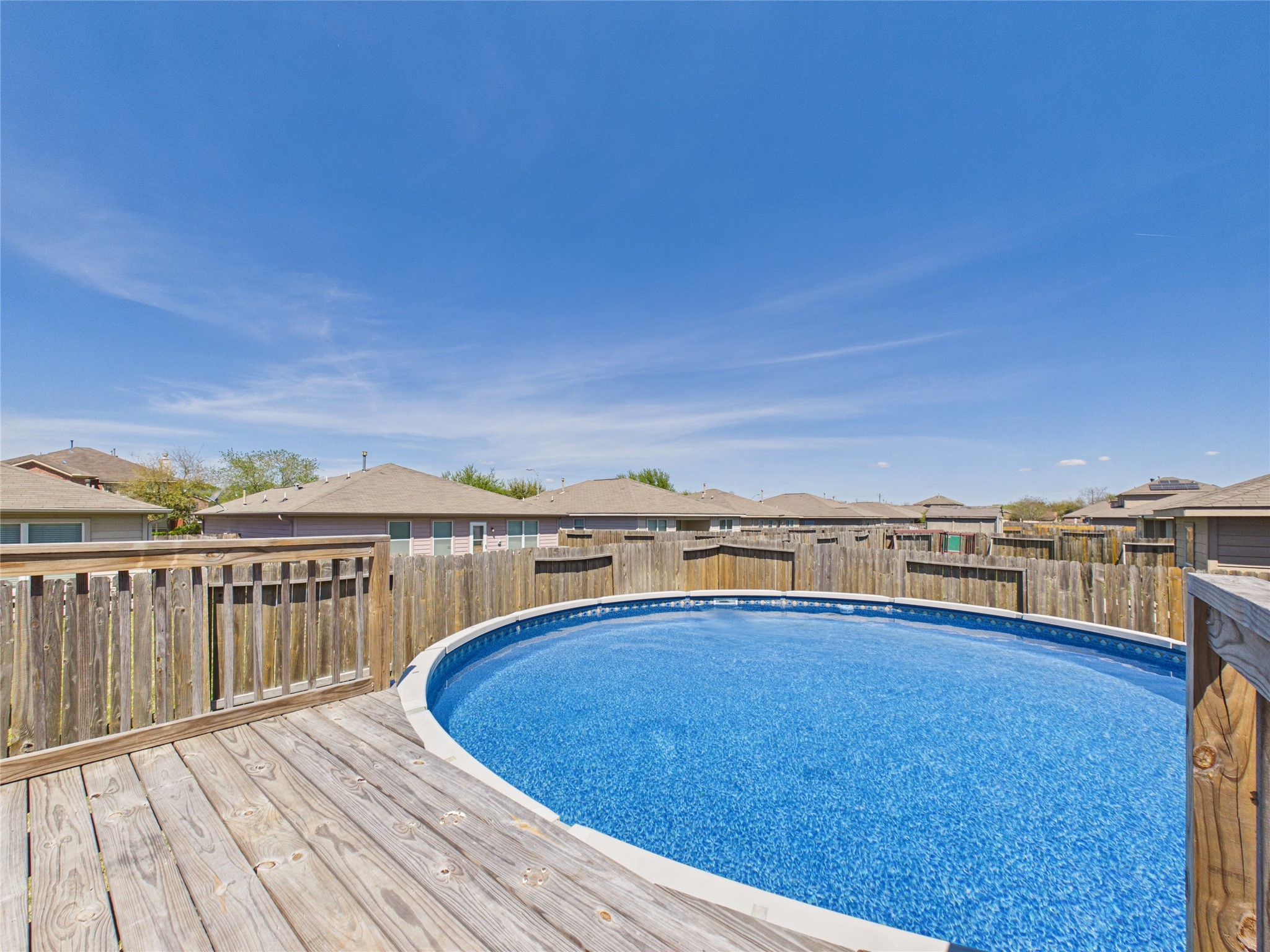 911 Marigold Road Baytown, TX 77521 - Photo 31 of 33 Enjoy summer days by your own above-ground pool, surrounded by a spacious wooden deck for relaxation and entertainment.