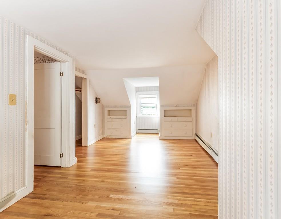 17 Nashoba Road Acton, MA 01720 - Photo 21 of 26 a view of an empty room with wooden floor and kitchen view