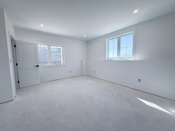 an empty room with closet and windows