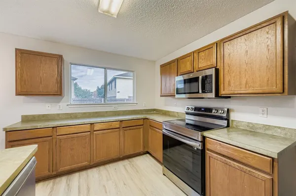 a kitchen with stainless steel appliances granite countertop a stove a sink and a microwave