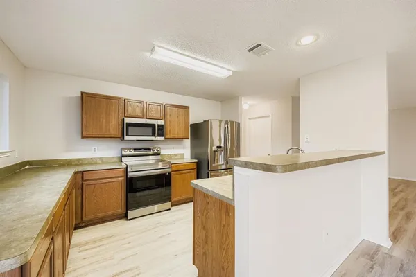 a kitchen with stainless steel appliances granite countertop a refrigerator a stove top oven a sink and dishwasher