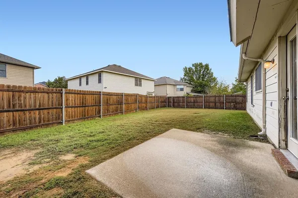 a view of a backyard with wooden fence