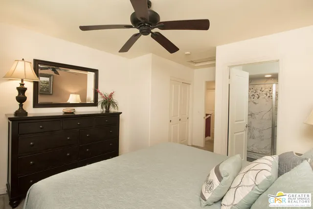 a bedroom with a bed and a mirror on the dresser