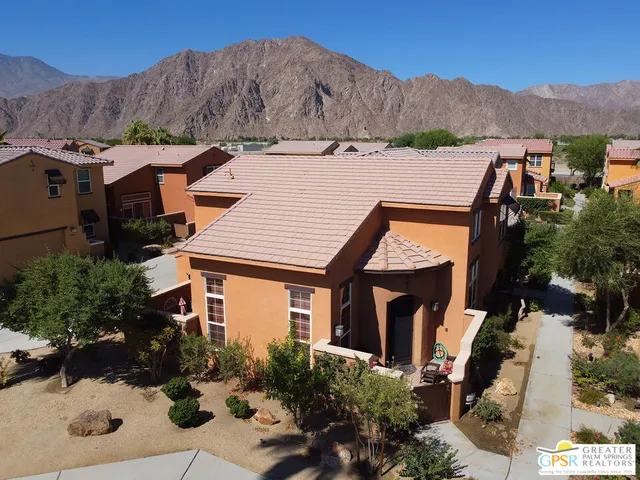 an aerial view of a house with a yard and a large tree