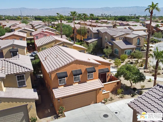 an aerial view of multiple houses with a yard