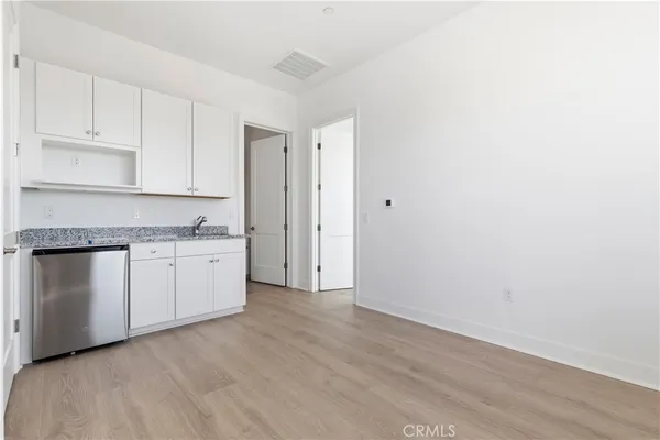 a kitchen with granite countertop white cabinets and white appliances