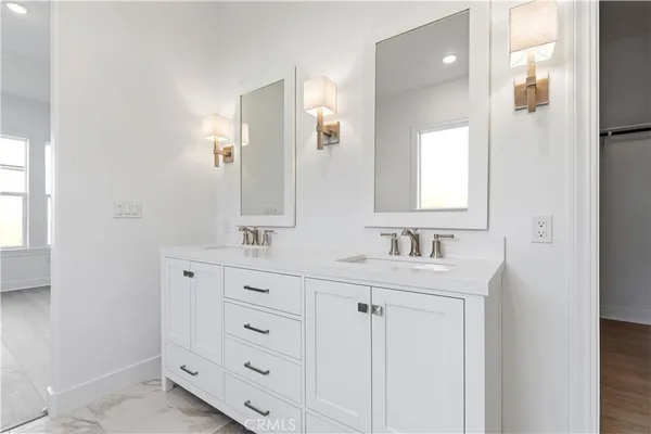 a bathroom with a double vanity sink and mirror with window