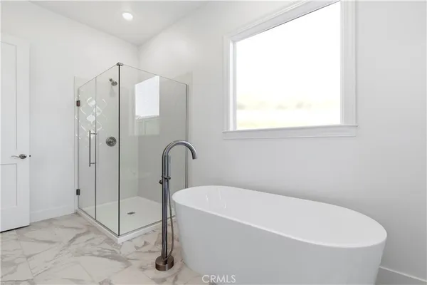 a white bath tub sitting next to a shower