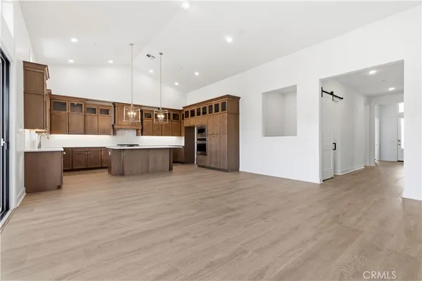 a large white kitchen with a refrigerator a oven and a sink