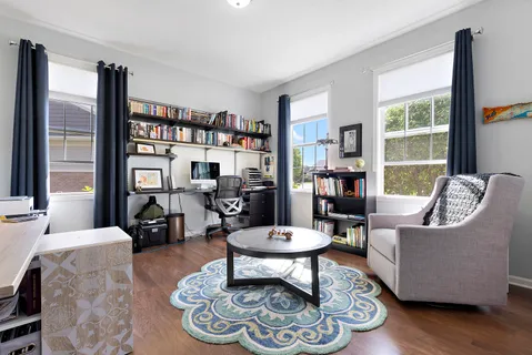 a living room with furniture a rug and a large window