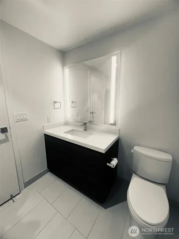 a large white kitchen with a sink and refrigerator