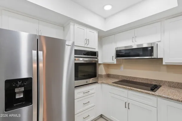 a kitchen with stainless steel appliances a refrigerator stove and microwave