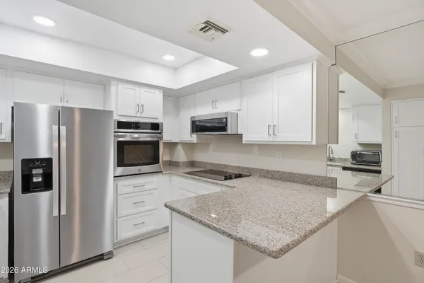 a kitchen with stainless steel appliances granite countertop a refrigerator stove microwave and sink