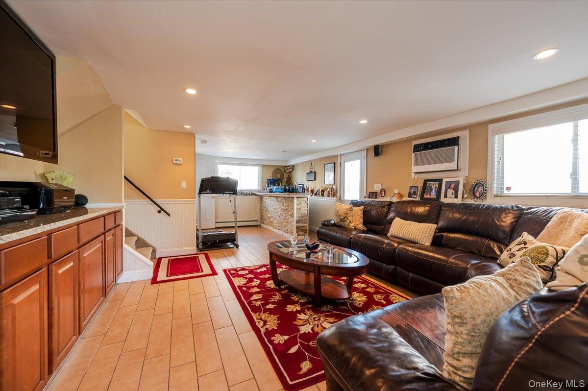 22 Cheshire Road Inwood, NY 11096 - Photo 12 of 25 a living room with furniture and a flat screen tv
