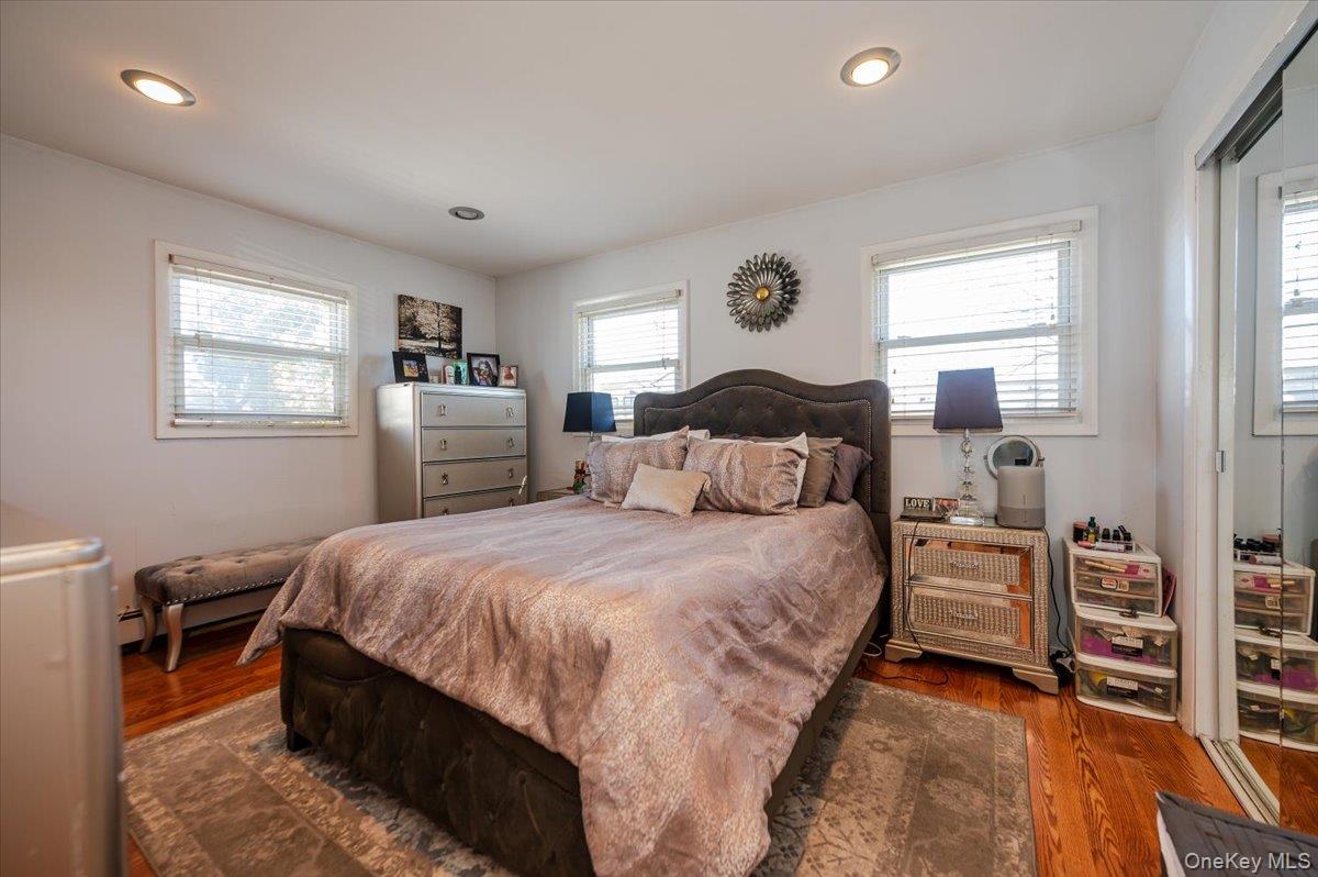22 Cheshire Road Inwood, NY 11096 - Photo 13 of 25 a bedroom with a bed and wooden floor