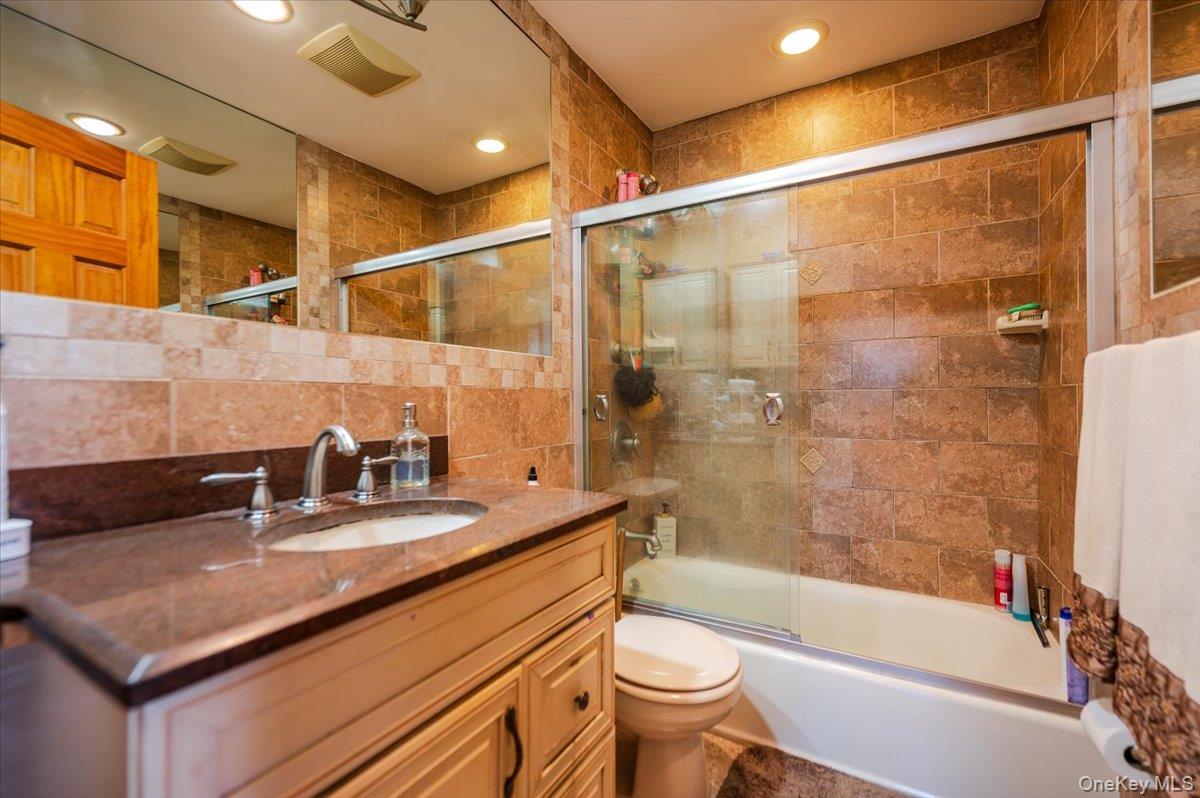 22 Cheshire Road Inwood, NY 11096 - Photo 16 of 25 a bathroom with a sink mirror toilet and bathtub