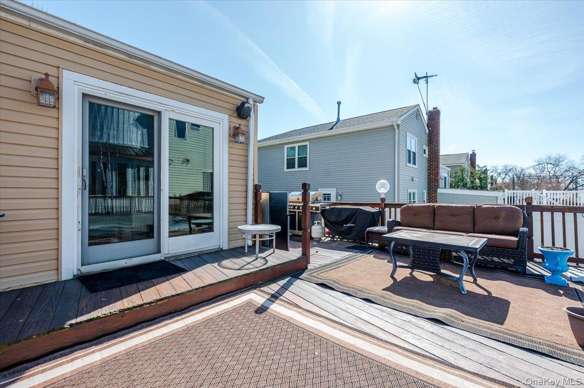 22 Cheshire Road Inwood, NY 11096 - Photo 20 of 25 a backyard of a house with barbeque oven table and chairs