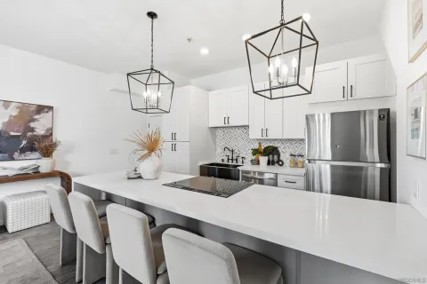 a kitchen with stainless steel appliances a table chairs and refrigerator