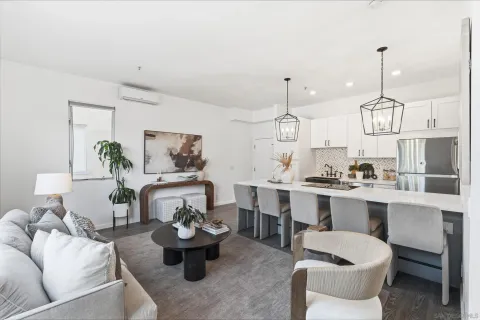 a living room with furniture kitchen view and a chandelier
