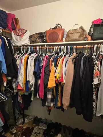 a view of walk in closet with clothes and shoes