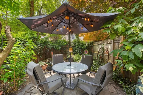 a patio with a table and chairs under an umbrella