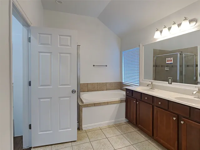a bathroom with a tub sink and mirror