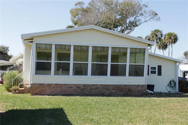 a view of a house with backyard and sitting area