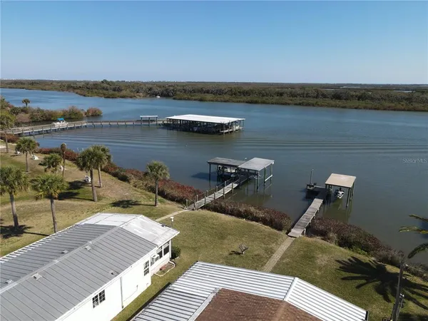 an aerial view of a house with a garden and lake view