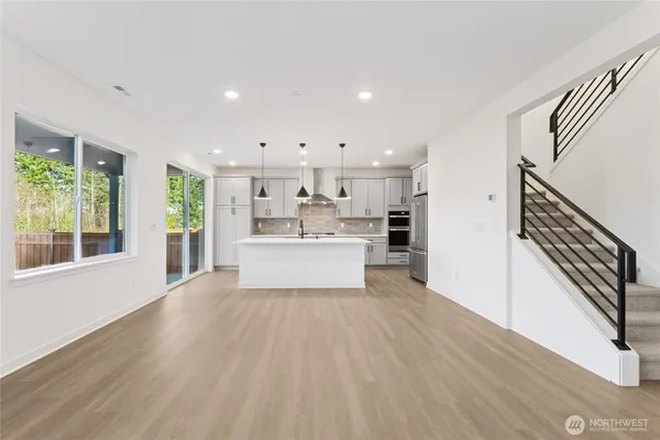 a view of a kitchen with wooden floor and electronic appliances