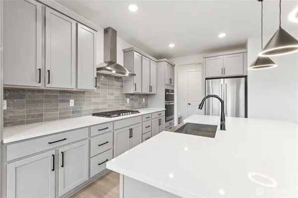 a kitchen with white cabinets appliances and sink