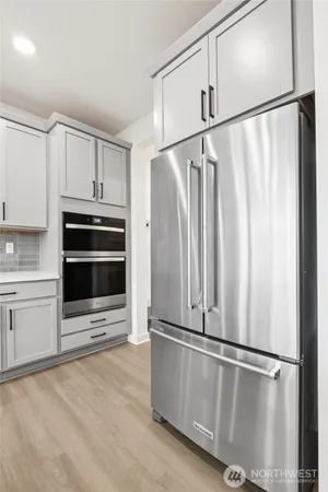 a kitchen with stainless steel appliances granite countertop a refrigerator and a stove top oven
