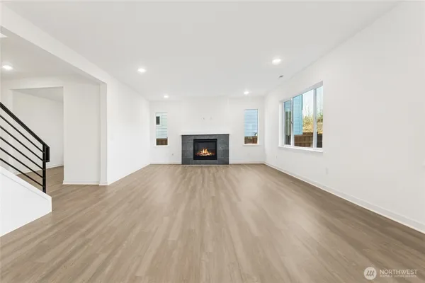 a view of empty room with wooden floor and fireplace