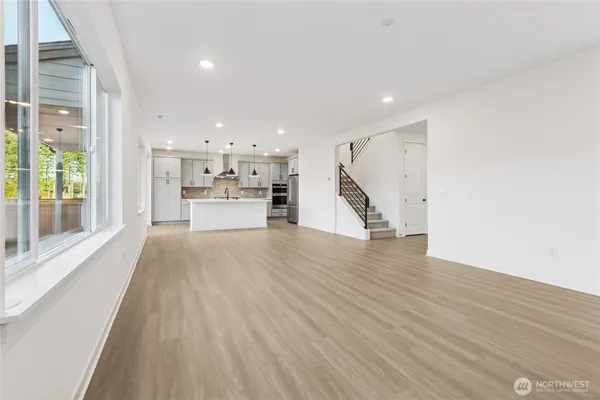 a view of a big room with wooden floor and windows