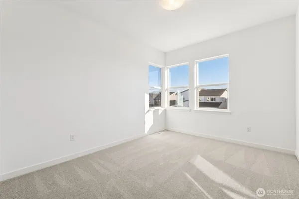 a view of an empty room with window and cabinet